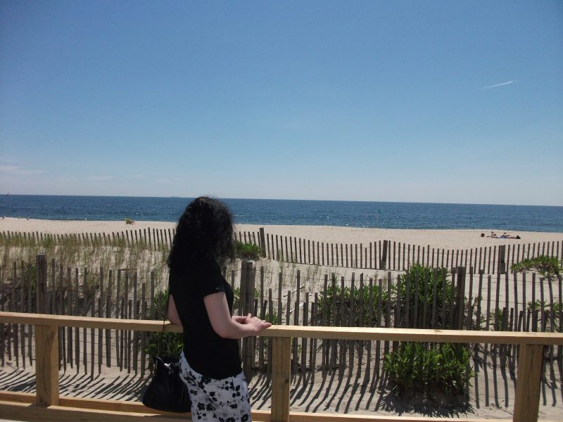 Person gazing at the beach, contemplating life's purpose.