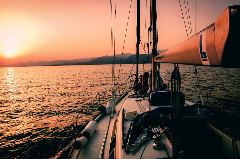 A boat sailing on the serene Aegeann Sea with a breathtaking sunset in the background | Solange Isaacs.