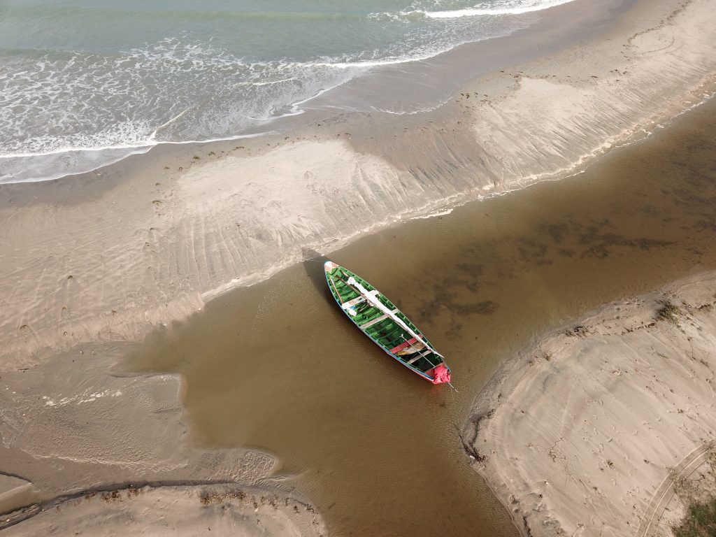 Imagem de um barco tranquilo na praia, representando as aventuras e o espírito de exploração do site "Here, There, And Everywhere".