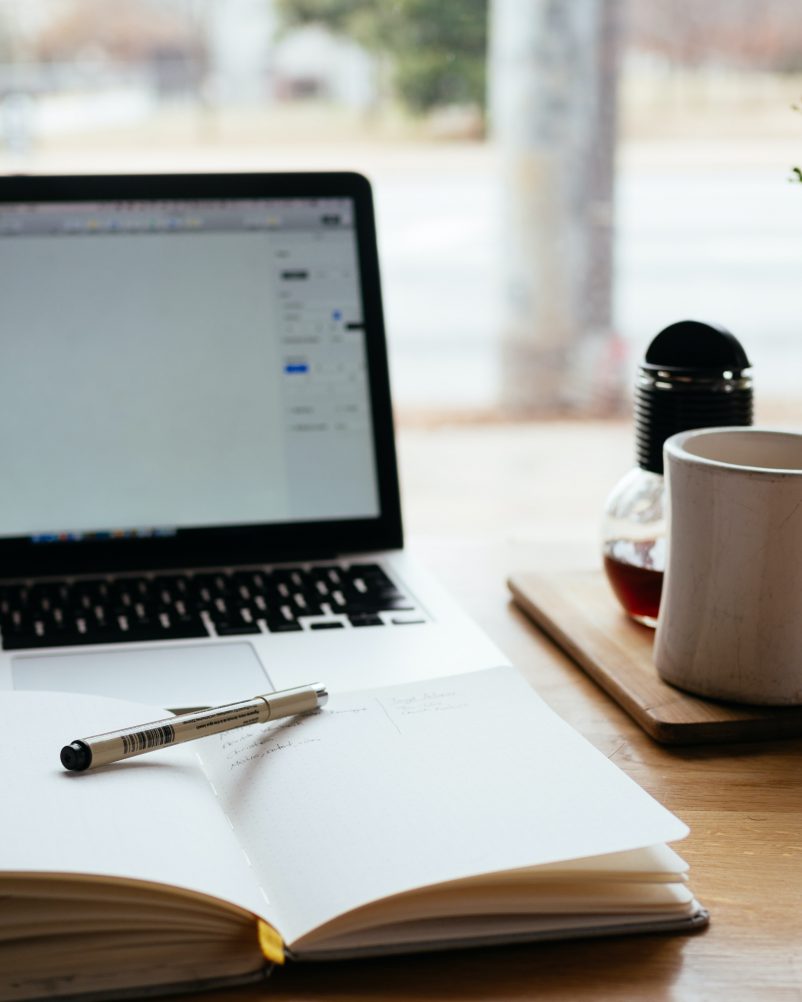 Laptop, book, and cup of coffee—a perfect setup for digital nomadism.