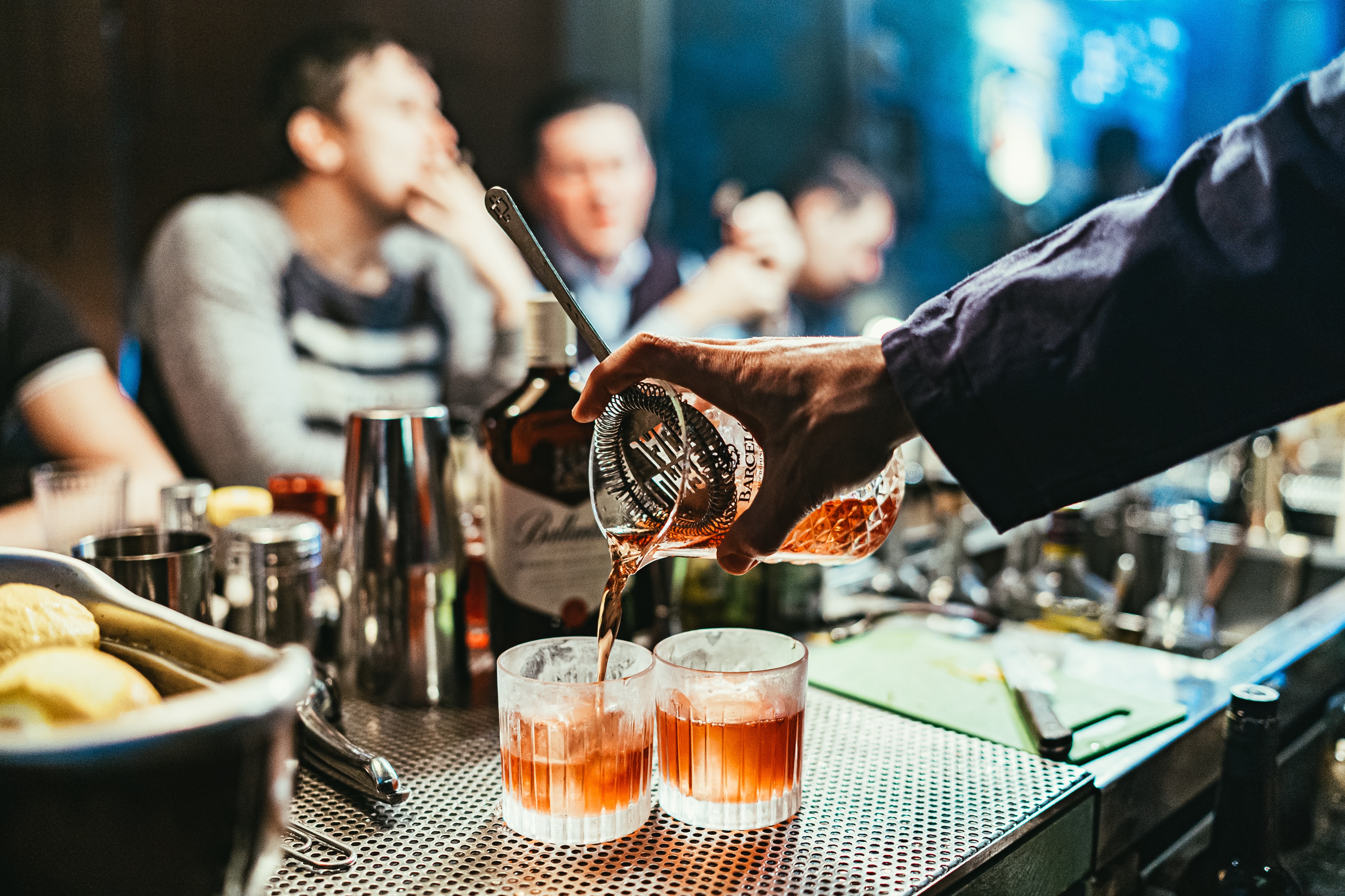 Bartender pouring drinks in a bustling New York City bar.