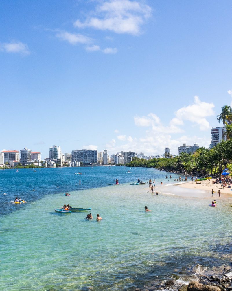A stunning view of Condado Beach in Puerto Rico, with golden sands, turquoise waters, and palm trees | Solange Isaacs.