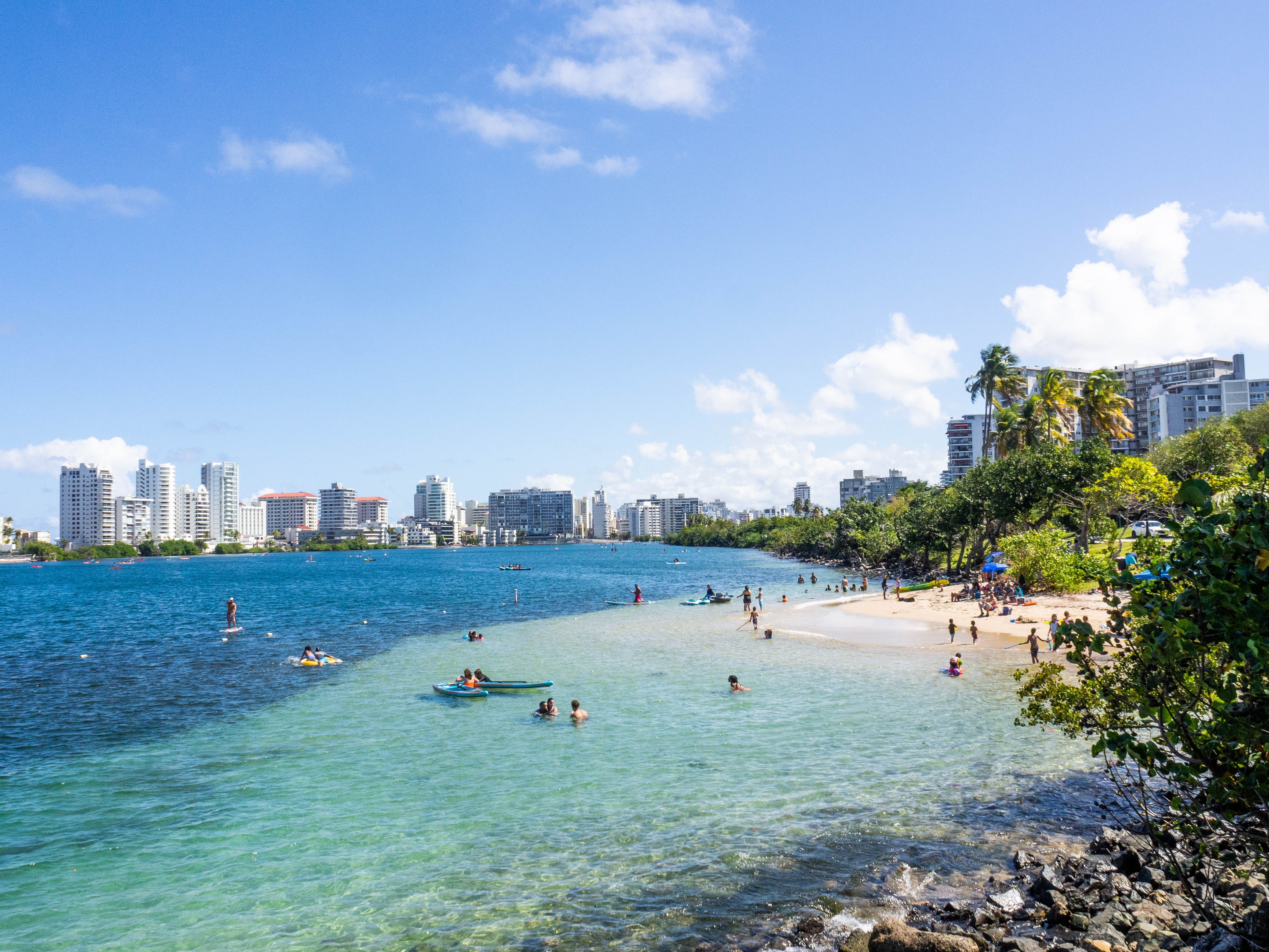 A stunning view of Condado Beach in Puerto Rico, with golden sands, turquoise waters, and palm trees | Solange Isaacs.