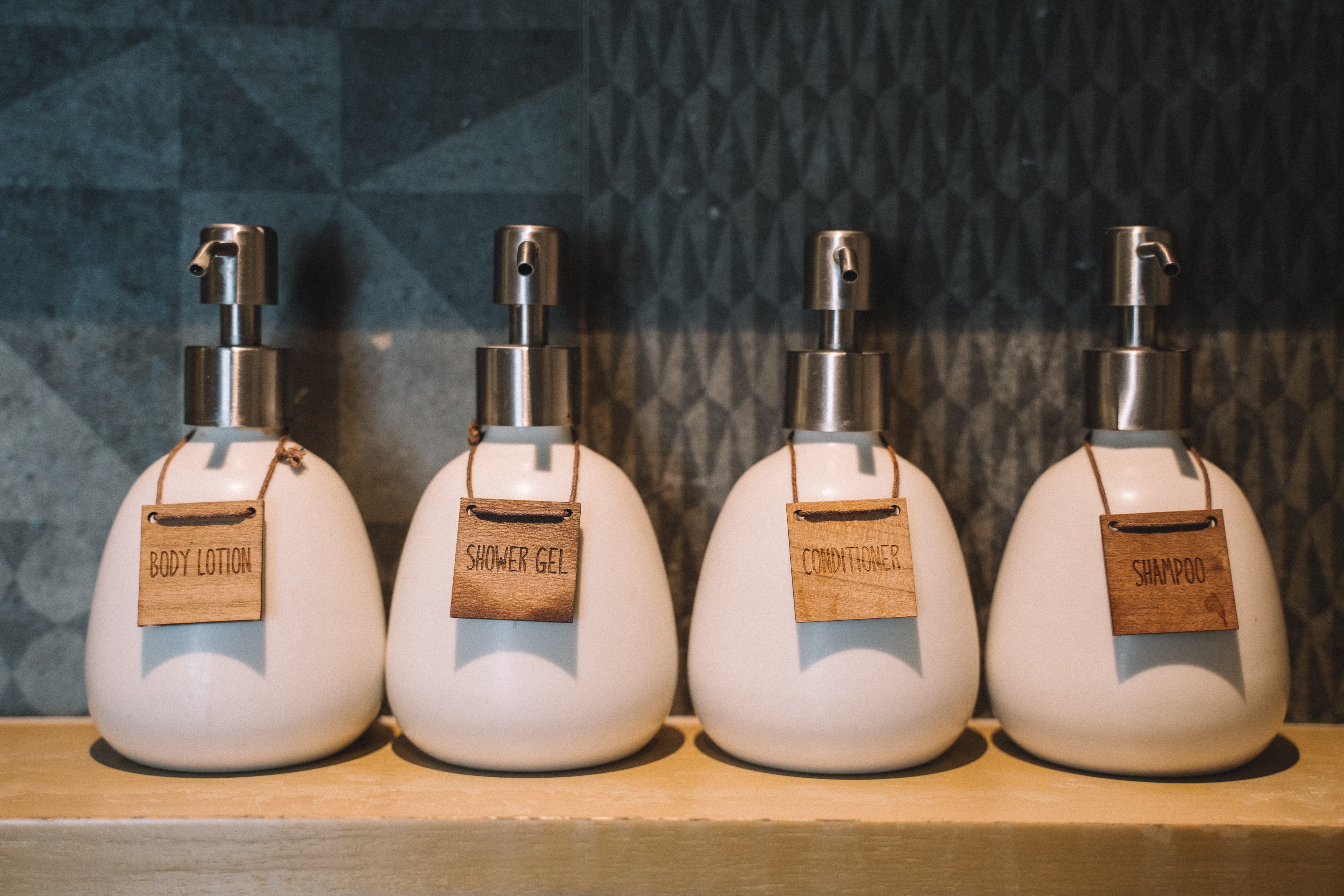 Bulk wall-mounted toiletries in a hotel bathroom.